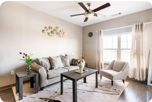 a living room with a couch and a ceiling fan at Uptown Stay and Adventures with Pool, Bars & Shops in Charlotte