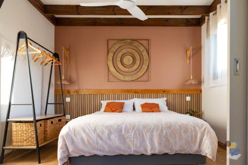 a bedroom with a large bed with orange pillows at L'oasis - Lodges 3 étoiles - DODOTERLA in Le Onzième