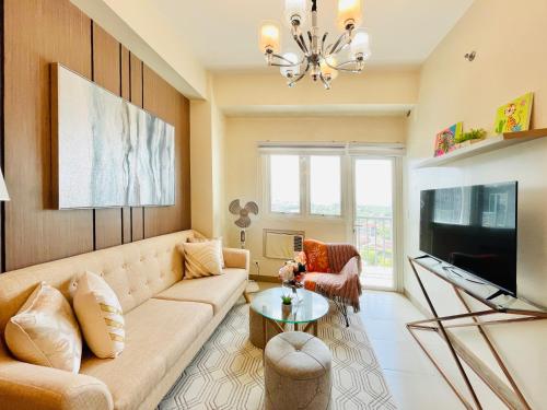 un salon avec un canapé et une télévision dans l'établissement 15 Elegant Urban Suite, à Cari Mayor