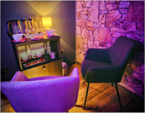 two chairs and a table in a room with purple lighting at Fantastica Casa Poppo in Bellano