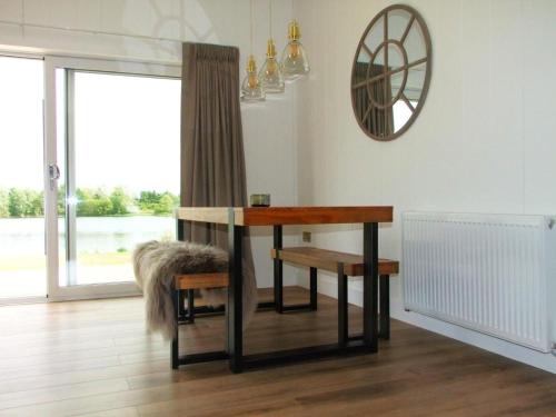 a table and bench in a room with a window at Phoenix Lodge - Luxury 2 ensuite bedrooms, lakeside views in Newark upon Trent