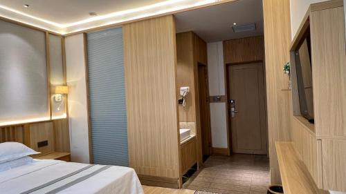 a hotel room with a bed and a bathroom at 嵩山居-丽晶精品民宿 in Dengfeng