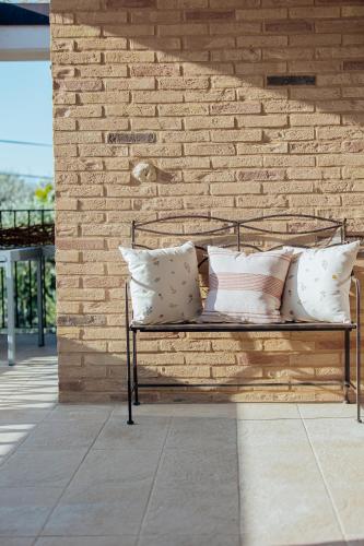 a metal bench with pillows on a brick wall at Agriturismo L'Elisir di Atena in Moscufo