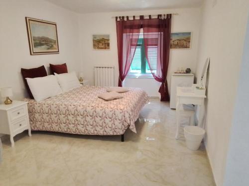 a white bedroom with a bed and a window at ANITA B&B in Uscio