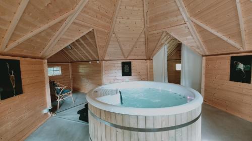 a large tub in a room with a wooden ceiling at La Bastide Champenoise - Chambres d'hôtes in Villers-Allerand