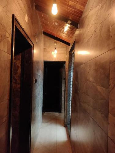 an empty hallway with a black door and a dark room at Bandarus Green Haven in Rājahmundry