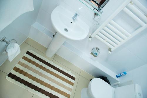 a white bathroom with a sink and a toilet at Residence Keruen in Atyraū
