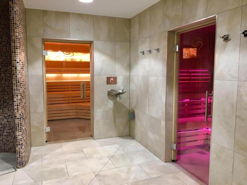 a bathroom with a walk in shower and a purple door at Lodge Nine in Newton Abbot