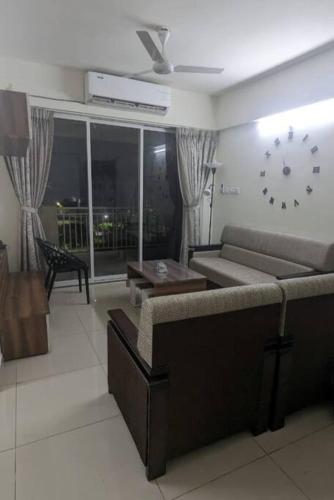 a living room with a couch and a clock on the wall at Mihan Home Stay in Nagpur