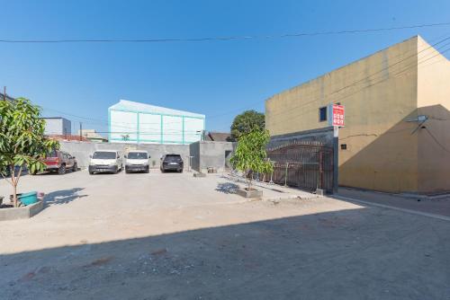 a parking lot with cars parked in front of a building at RedDoorz at Kedawung Aurel Cirebon in Plered