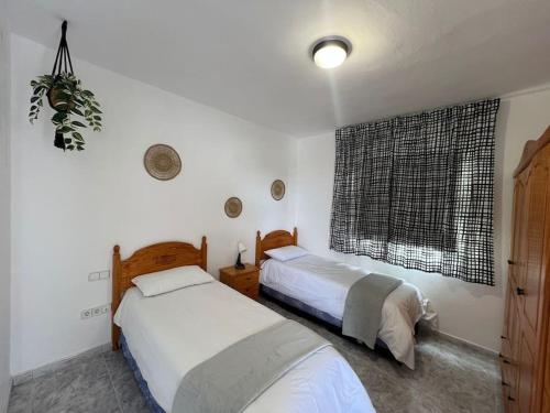 a bedroom with two beds and a window at Los Adejo in Moya