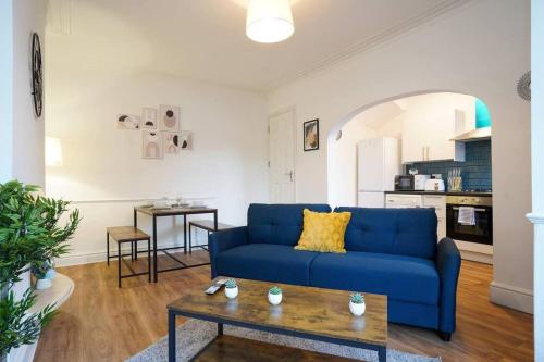 a living room with a blue couch and a table at 3 Bedroom Home with Free parking in Leeds