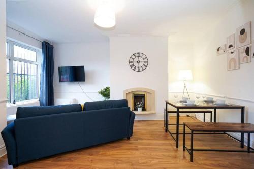 a living room with a blue couch and a table at 3 Bedroom Home with Free parking in Leeds