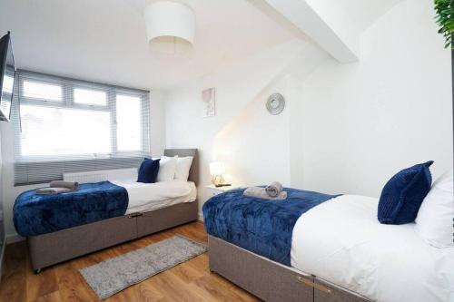 a bedroom with two beds and a window at 3 Bedroom Home with Free parking in Leeds