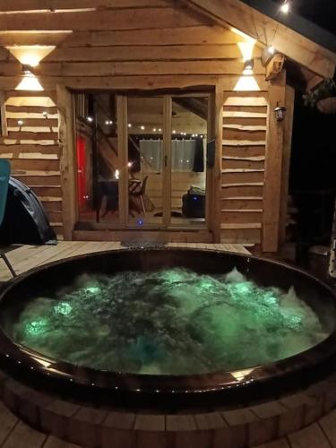 a large hot tub with green water in a room at Les Étoiles de Bevy Chalet insolite Love Room in Septmoncel