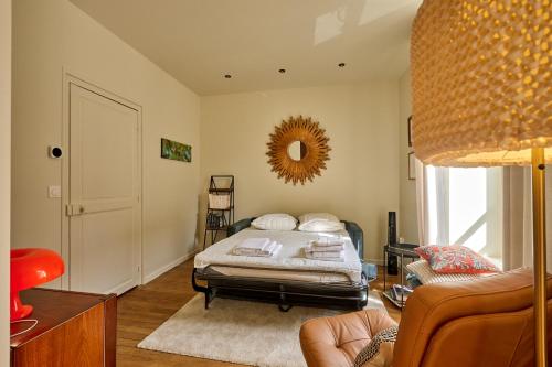 une chambre avec un lit et un miroir au mur dans l'établissement Le 10Cath Centre historique Nevers by Primoconciergerie, à Nevers