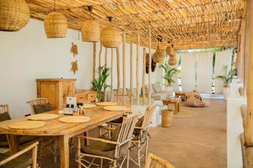 a dining room with a wooden table and chairs at Boho Boutique Hotel - Beachfront , Adults Only , Private Pool in Kiwengwa