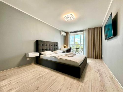 a bedroom with a bed and a large window at ApartPoltava апартаменти бізнес-класу в престижній НОВОбудові з панорамним балконом ЦЕНТР in Poltava