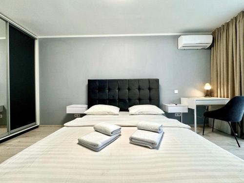 a bedroom with a large bed with three pillows on it at ApartPoltava апартаменти бізнес-класу в престижній НОВОбудові з панорамним балконом ЦЕНТР in Poltava