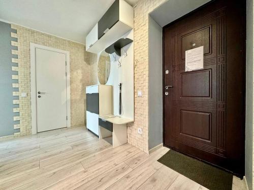 a hallway with a wooden door and a room at ApartPoltava апартаменти бізнес-класу в престижній НОВОбудові з панорамним балконом ЦЕНТР in Poltava