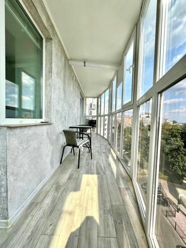 a room with a bench in a building with windows at ApartPoltava апартаменти бізнес-класу в престижній НОВОбудові з панорамним балконом ЦЕНТР in Poltava