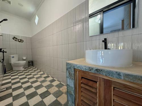 een badkamer met een wastafel en een toilet bij Gecko Villa in Lovina