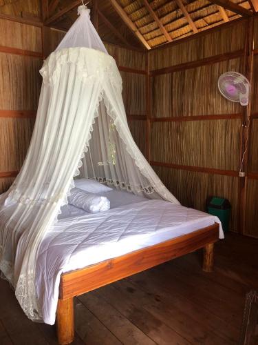 a bed with a mosquito net in a room at Frits Homestay in Kri