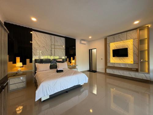 een slaapkamer met een bed en een tv aan de muur bij Gecko Villa in Lovina