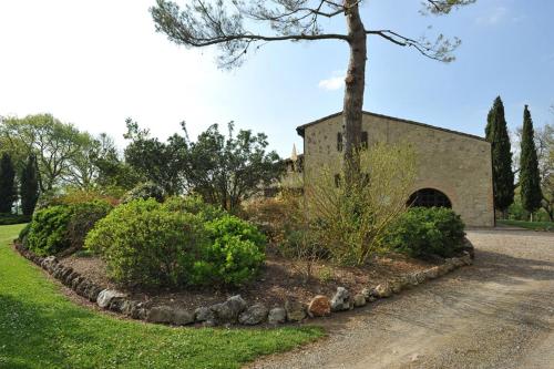 a garden in front of a building with a tree at Fattoria Agriturismo Nerbona in Casole dʼElsa