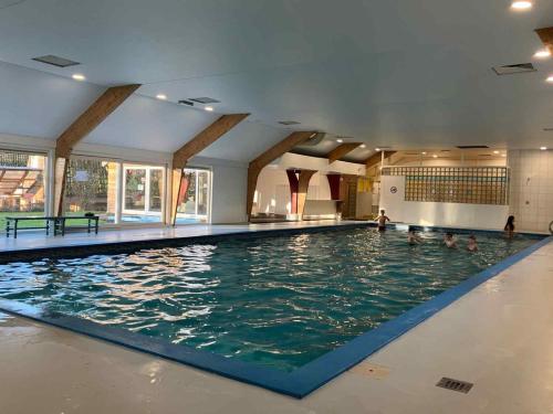 a large swimming pool with people in the water at The Green Apple Durbuy in Durbuy