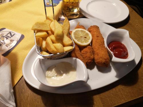 a plate of food with fish and french fries and ketchup at Kirchenwirt Sankt Aegidi in Sankt Aegidi