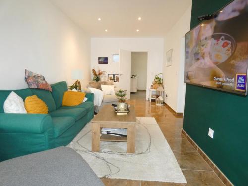a living room with a green couch and a table at 195 sqm luxury apartment in L'Alfas del Pi