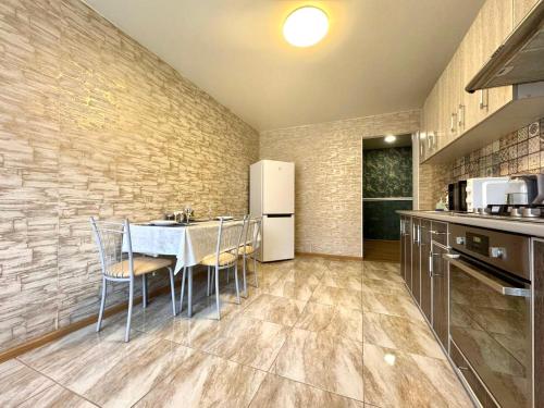 a kitchen with a table and chairs and a refrigerator at ApartPoltava Затишна квартира в новобудові, панорамний балкон, банківський чек in Poltava