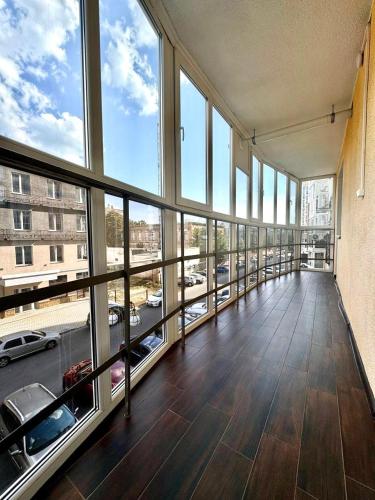 a large room with a balcony with a view of a parking lot at ApartPoltava Затишна квартира в новобудові, панорамний балкон, банківський чек in Poltava