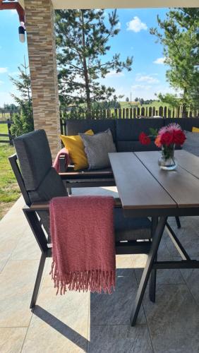 a patio with a table and a couch and a table and chairs at Kavicsház in Vlăhiţa