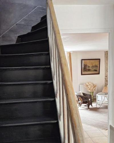 - un escalier noir dans le salon avec un canapé dans l'établissement Maison de ville en plein centre historique, à Conflans-Sainte-Honorine