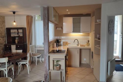 a kitchen and dining room with a table and a kitchen and a dining room at Maison de ville en plein centre historique in Conflans-Sainte-Honorine