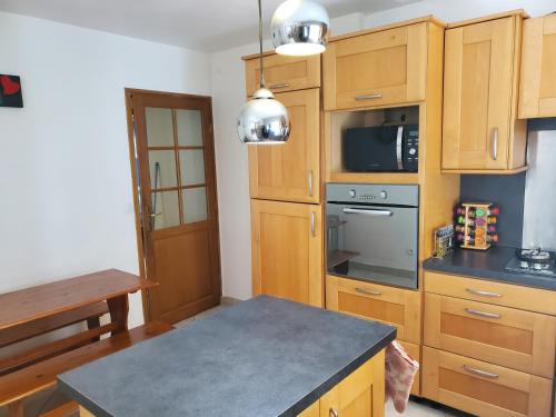 une cuisine avec des armoires en bois et un four à plaques de cuisson dans l'établissement Belle Maison Sud Seine-et-Marne, à Rubelles