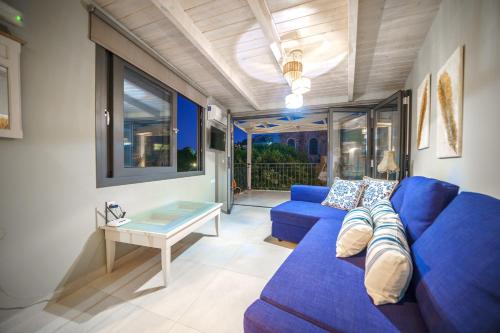 a living room with a blue couch and a table at RODIBLUE VILLAGE Apartments in Rodia