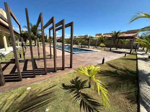 ein Resort mit Swimmingpool und Palmen in der Unterkunft Portal do Mar-Casa 01 in Luis Correia