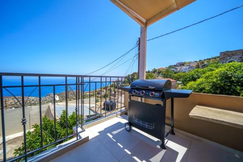 a grill on a balcony with a view of the ocean at RODIBLUE VILLAGE Apartments in Rodia