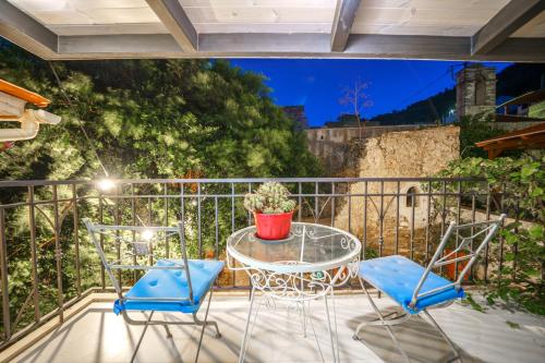 a patio with a table and chairs on a balcony at RODIBLUE VILLAGE Apartments in Rodia