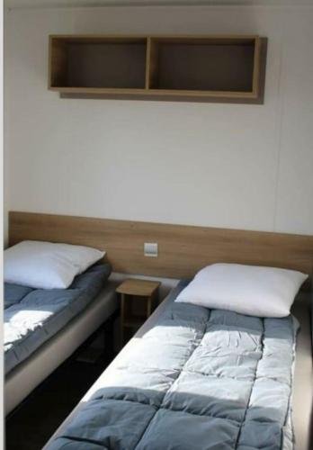 une chambre avec deux lits et une petite table dans l'établissement Mobil home contis, à Saint-Magne