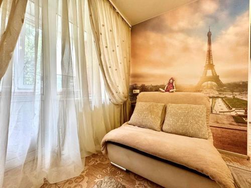 a bedroom with a bed and a painting of the eiffel tower at ApartPoltava Французький шик у центрі Полтави, 4 спальних місця, Корпусний парк in Poltava