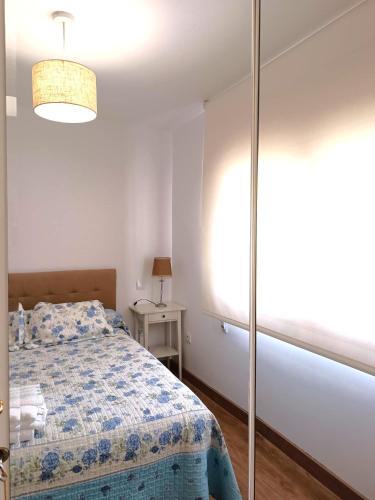 a bedroom with a bed and a window and a lamp at Apartamentos rurales 'Los Soportales' in Tendilla