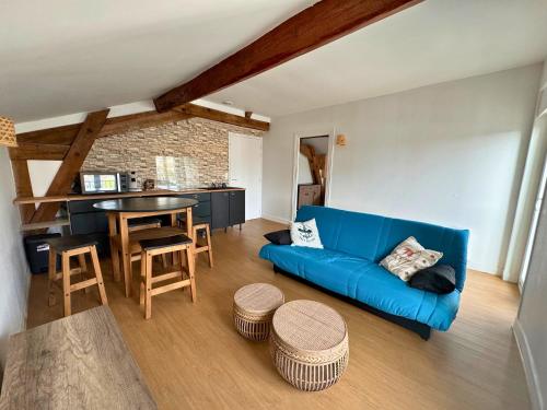 un salon avec un canapé bleu et une table dans l'établissement Le Chanzy - Fibre - Centre - Netflix, à Dax