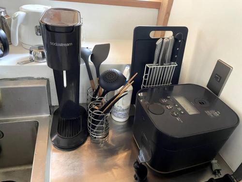 a kitchen counter with a blender and other kitchen utensils at Momo's Inn - momo no yado in Aone