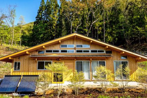 a house with solar panels in front of it at Momo's Inn - momo no yado in Aone