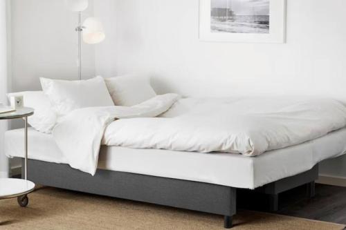 a bed with white sheets and pillows on it at Dollis Hill One Bedroom Apartment NW2 in London