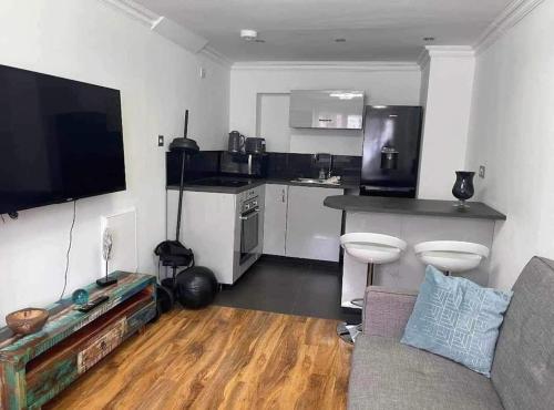 a living room with a couch and a kitchen at Dollis Hill One Bedroom Apartment NW2 in London